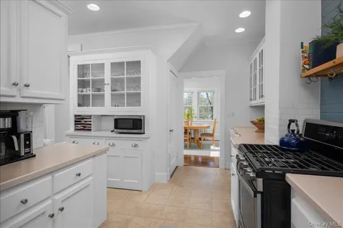 a kitchen with a stove and white cabinets