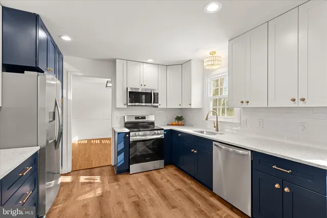 a kitchen with stainless steel appliances a sink cabinets and a refrigerator
