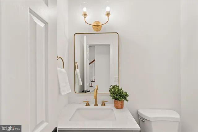 a bathroom with a sink toilet and mirror