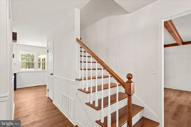 a view of staircase with wooden floor and white walls