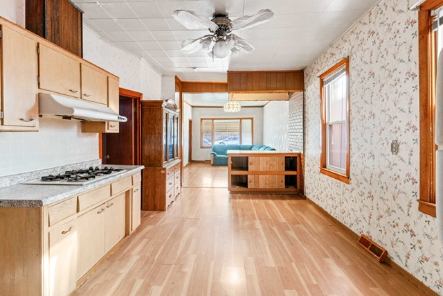3047 South Broad Street Chicago, IL 60608 - Photo 9 of 15 a kitchen with stainless steel appliances granite countertop a stove a refrigerator a sink dishwasher and a dining table with wooden floor