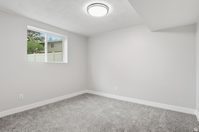 629 King Circle Layton, UT 84041 - Photo 22 of 26 Carpeted room featuring a white-framed window, neutral gray walls, a flush-mount ceiling light fixture, and white baseboards