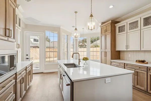 a kitchen that has a lot of cabinets and wooden floor
