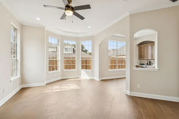 a view of an empty room with a window and wooden floor