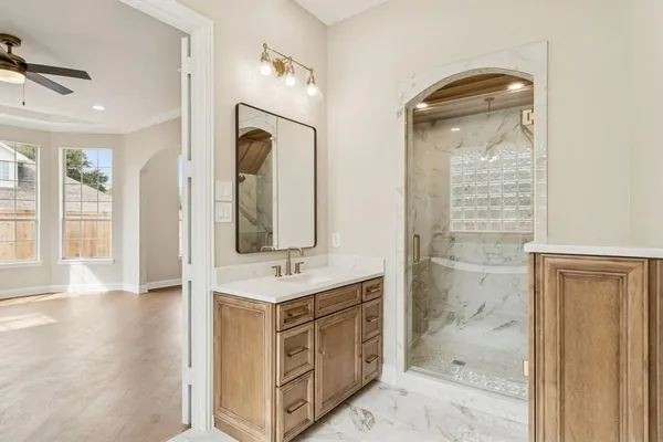 a spacious bathroom with a shower a sink and a mirror
