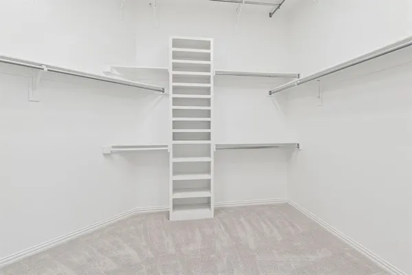 a view of walk in closet with empty racks