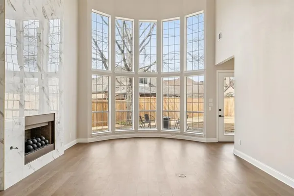 a view of an empty room with a window and fire place