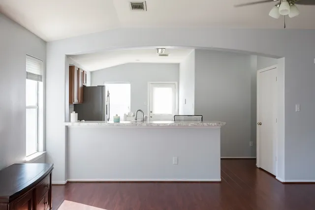 a view with granite countertop a sink and a refrigerator