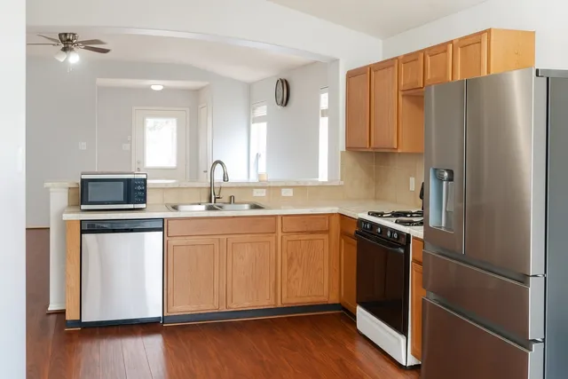 a kitchen with stainless steel appliances granite countertop a refrigerator stove and sink