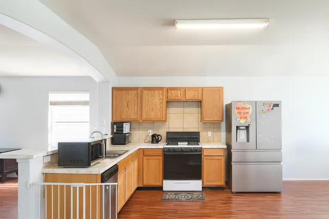 a kitchen with stainless steel appliances a stove top oven a sink a counter space and cabinets