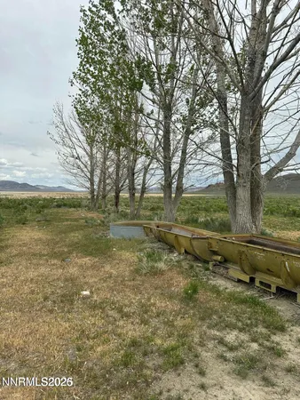 a view of a green field with wooden fence