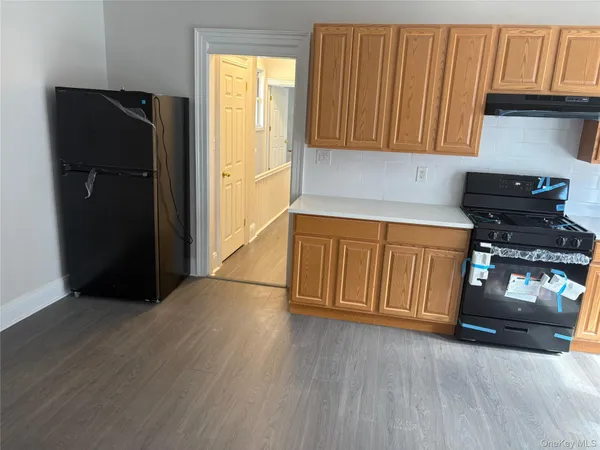 a kitchen with granite countertop wooden cabinets and a refrigerator