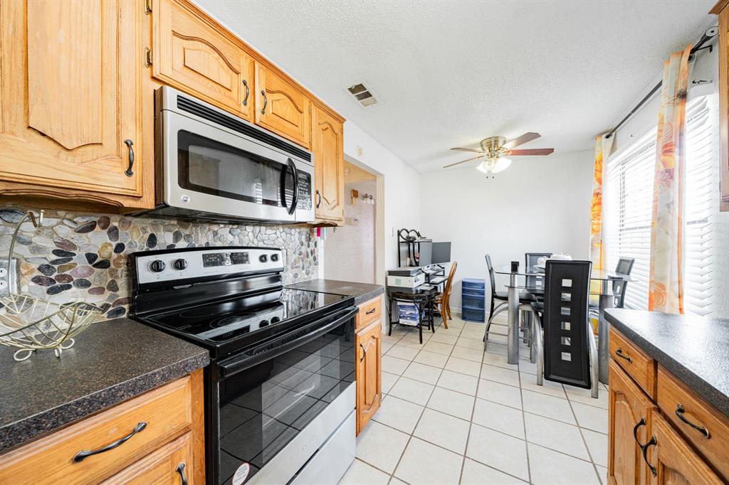 1524 Crowell Road Kaufman, TX 75142 - Photo 16 of 28 a kitchen with stainless steel appliances a stove a sink and a microwave