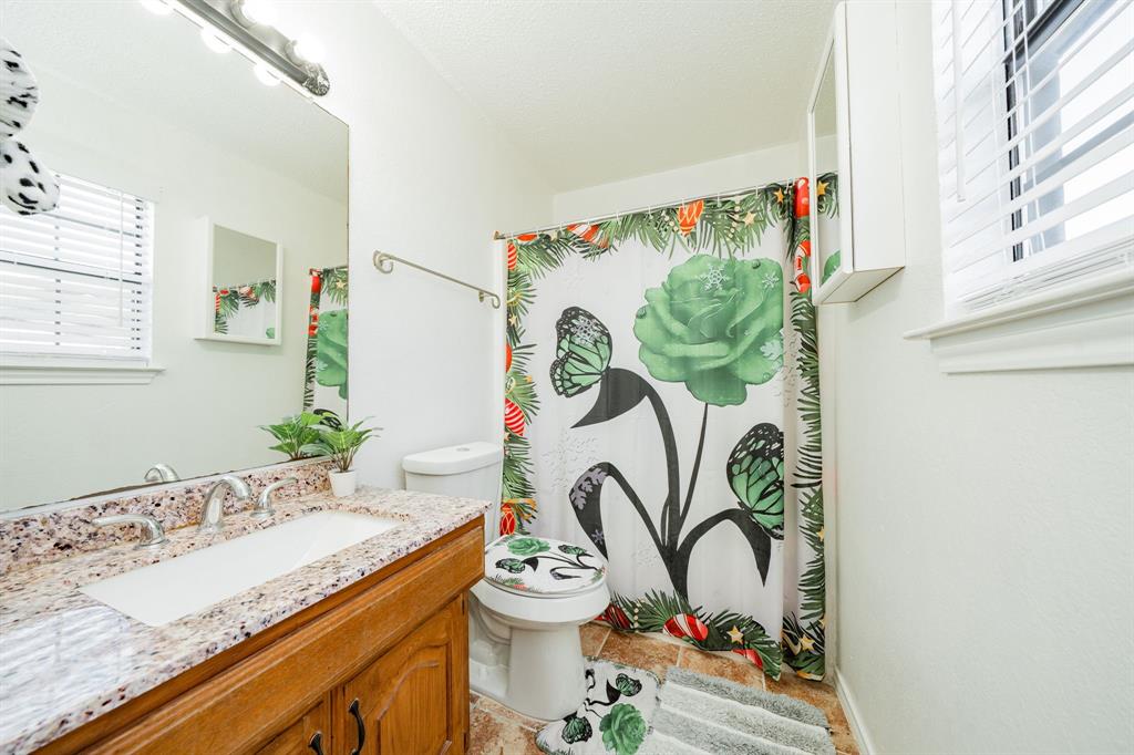 1524 Crowell Road Kaufman, TX 75142 - Photo 20 of 28 a bathroom with a granite countertop sink a large mirror and a window