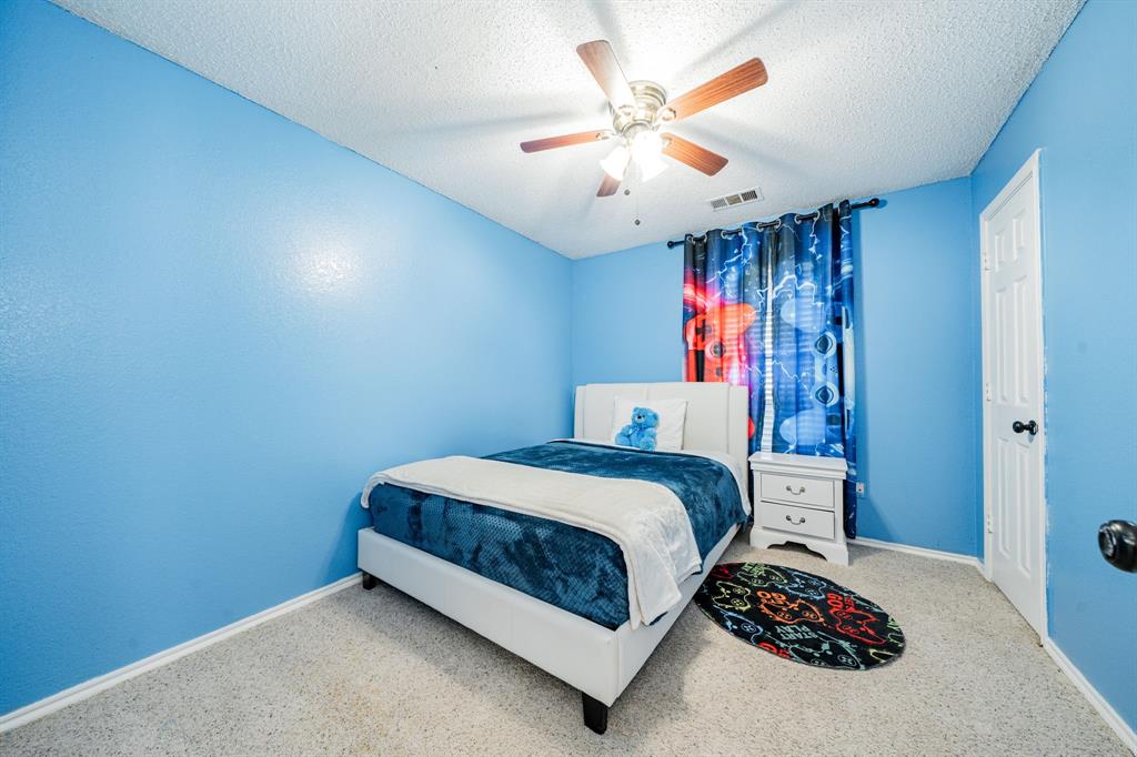 1524 Crowell Road Kaufman, TX 75142 - Photo 21 of 28 a bedroom with a bed and a chandelier