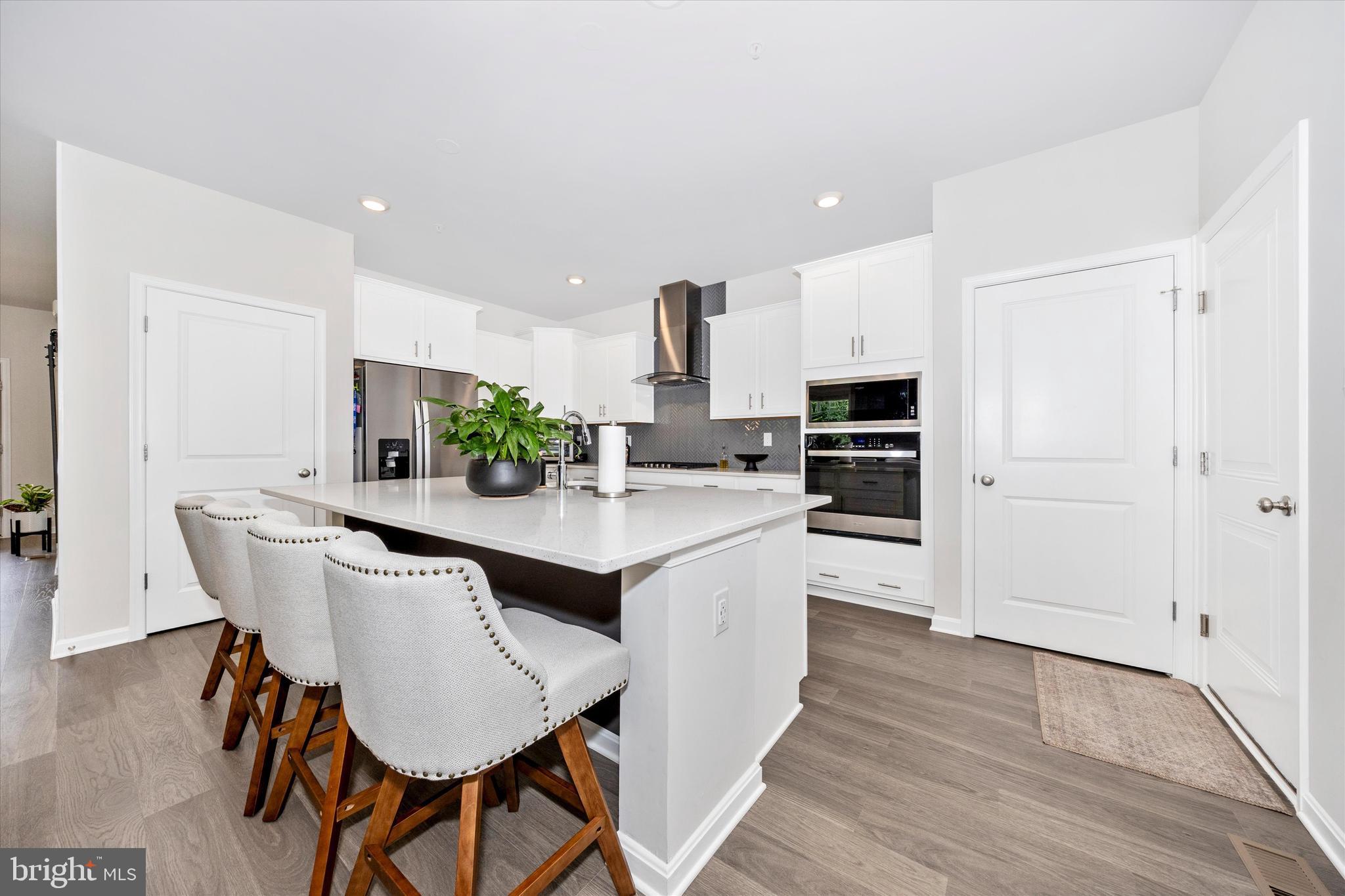 700 Bond Street Frederick, MD 21701 - Photo 11 of 49 a kitchen with stainless steel appliances a dining table chairs and wooden floor