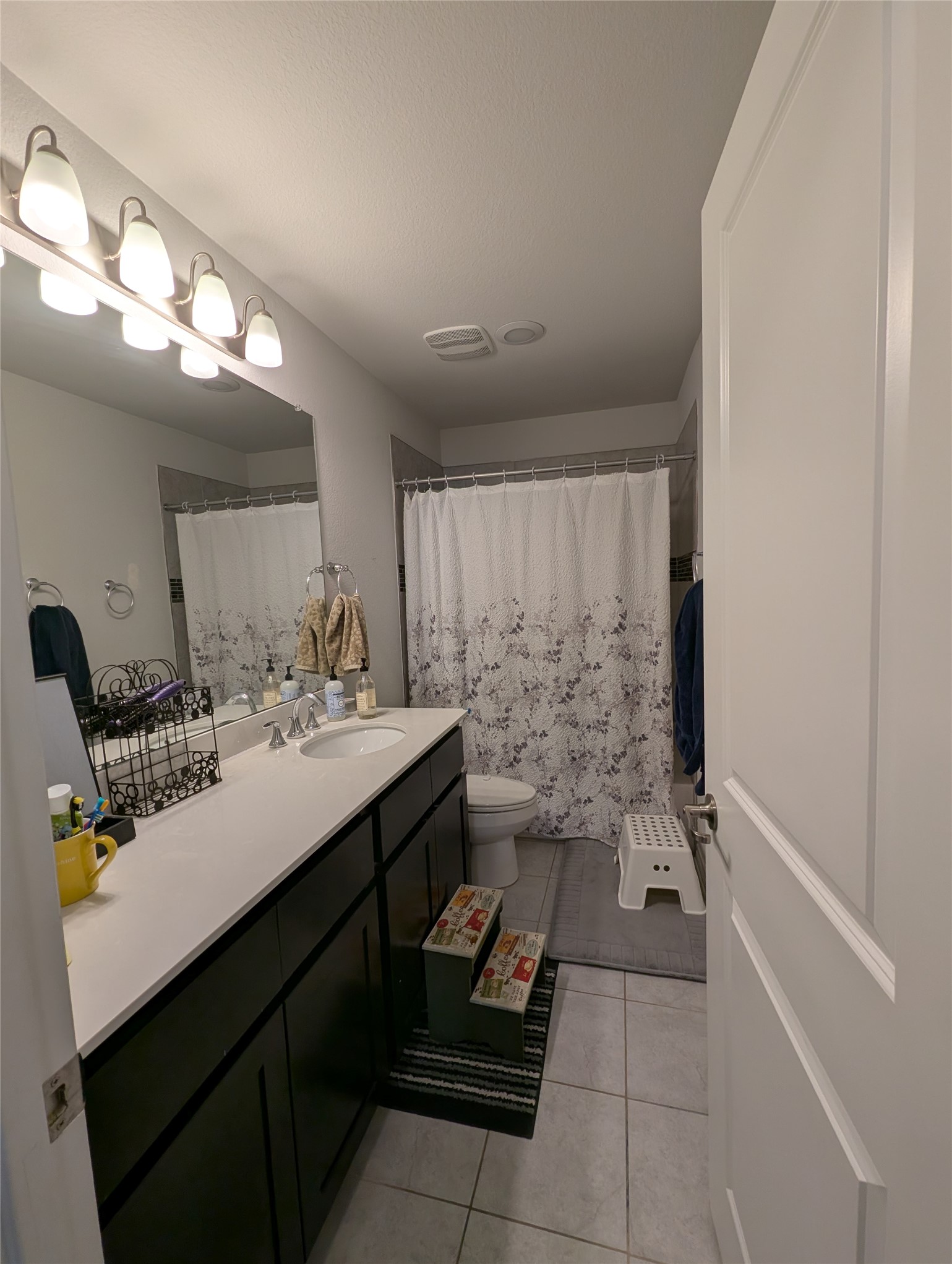 14502 McCoy Loop Austin, TX 78717 - Photo 8 of 26 Bathroom featuring a single vanity with dark cabinetry and a light-toned countertop, a rectangular undermount sink, and a chrome faucet