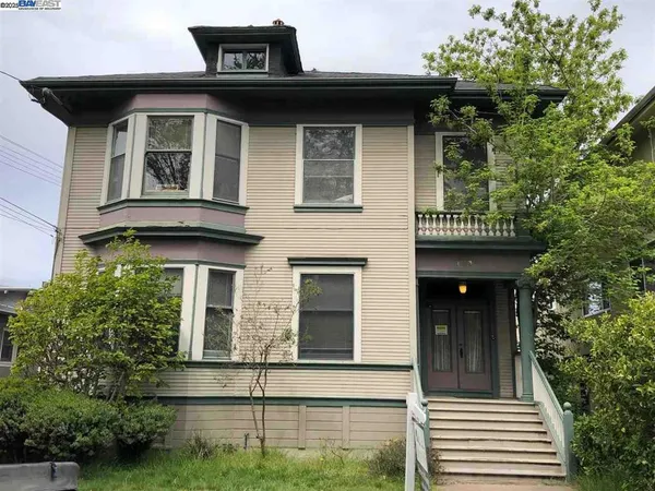 a view of a house with large windows and a small yard