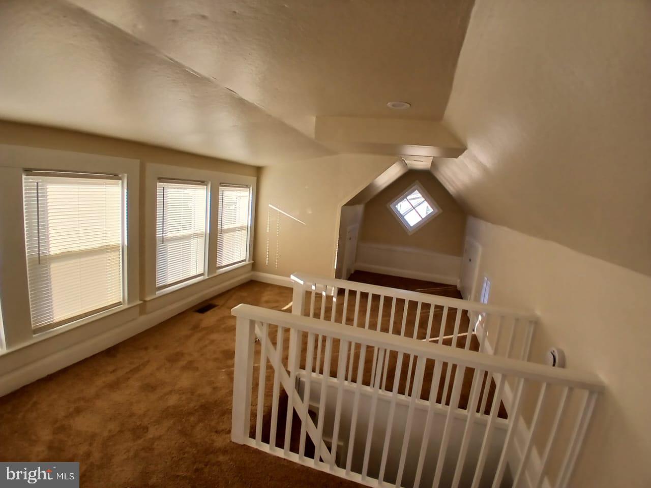 5505 Tramore Road Baltimore, MD 21214 - Photo 14 of 28 a view of an empty room with wooden floor and windows