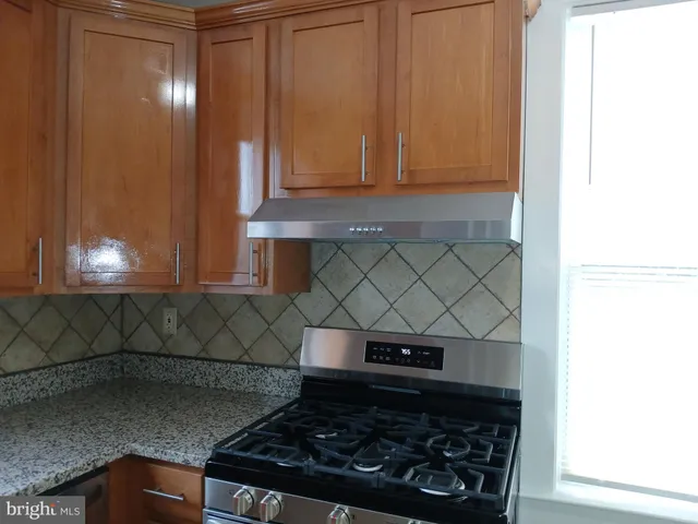 a kitchen with stainless steel appliances granite countertop a stove a refrigerator and a sink