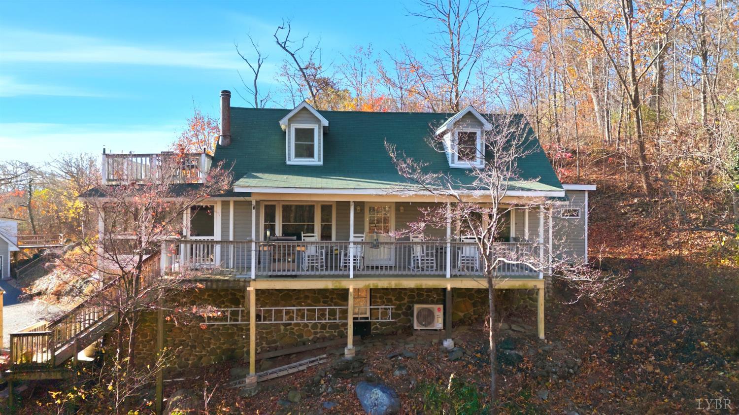 a view of a house with a wooden deck and a backyard