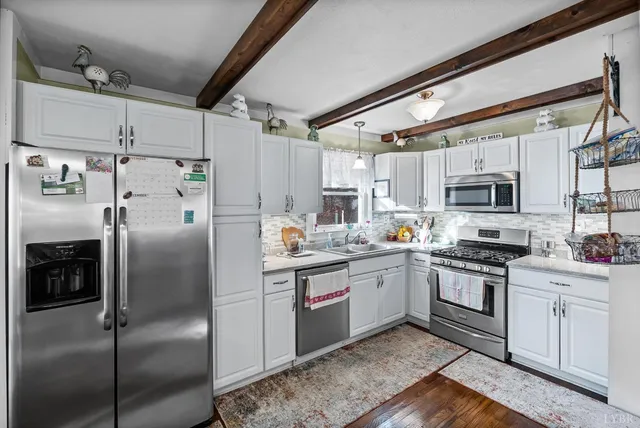 a kitchen with stainless steel appliances granite countertop a refrigerator a stove and a sink