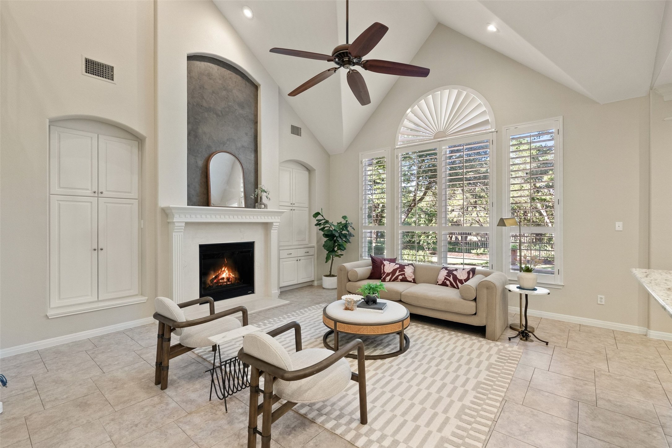 8215 Dark Ridge Cove Austin, TX 78737 - Photo 10 of 40 High ceilings, large windows, plantation shutters, and a fireplace flanked by custom storage define the main living room.