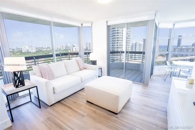 a living room with furniture and a floor to ceiling window
