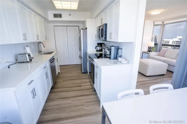 a kitchen with sink a counter top space and living room