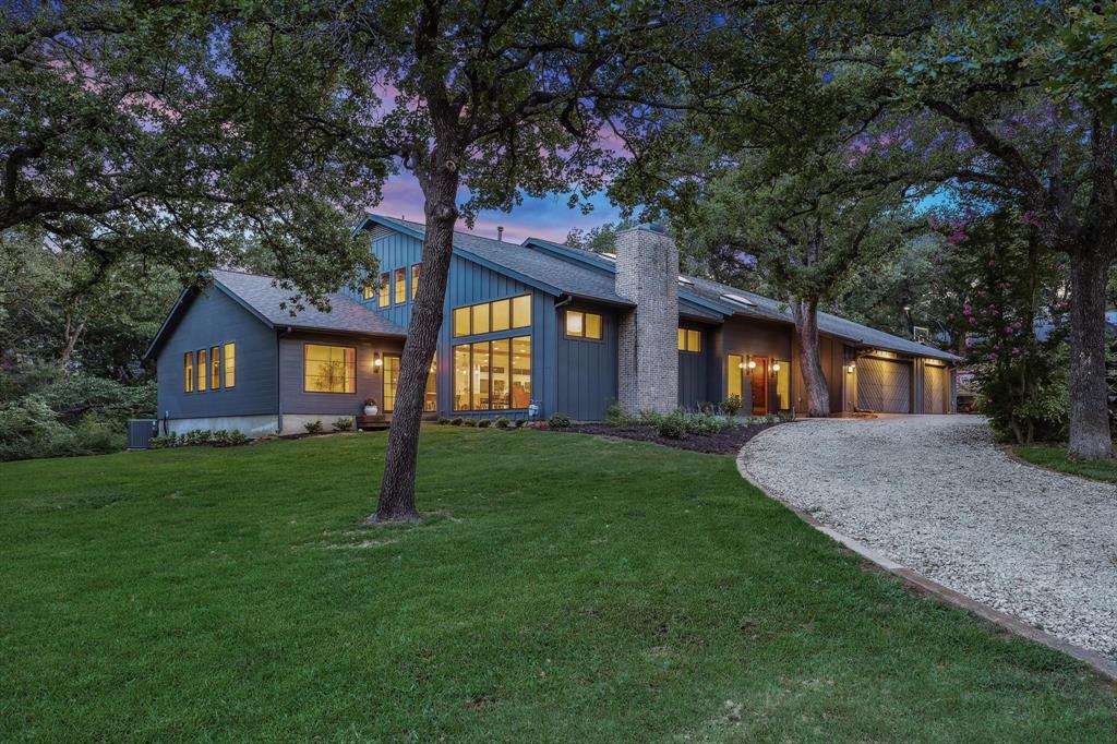 a front view of a house with a yard and trees