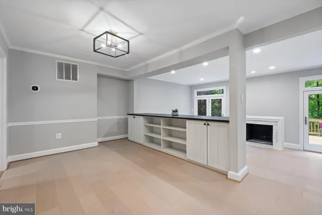 an empty room with windows and fireplace