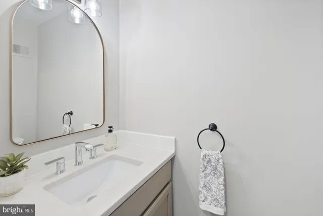 a bathroom with a sink vanity and a mirror