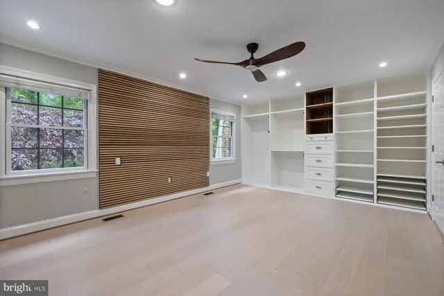 a view of an empty room with a windows and ceiling fan