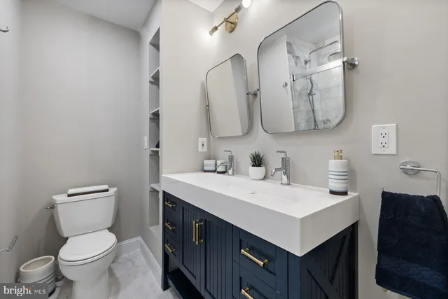a bathroom with a sink vanity mirror and toilet