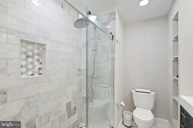 a white toilet sitting next to a bathroom sink