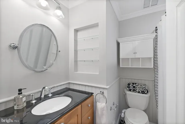 a bathroom with a toilet a sink and mirror