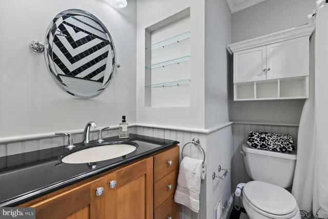 a bathroom with a sink a toilet and mirror