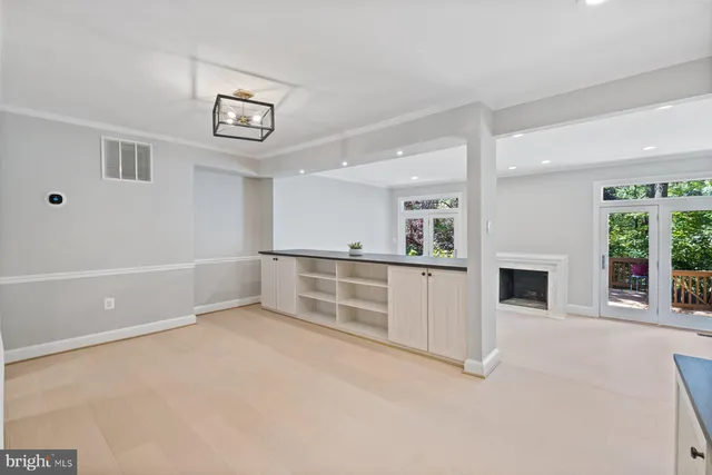 an empty room with windows and fireplace