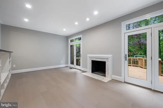 a view of an empty room with a fireplace and a window