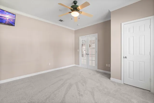 an empty room with closet and a ceiling fan