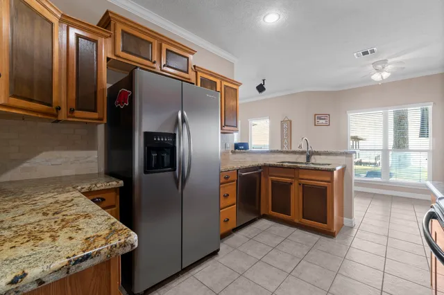 a kitchen with stainless steel appliances granite countertop white cabinets a stove top oven a sink and dishwasher