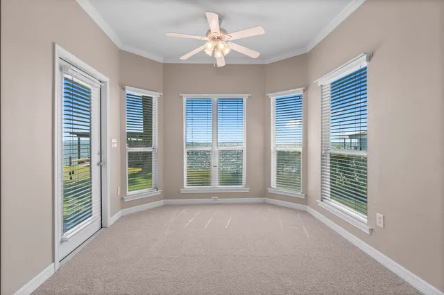 a view of empty room with window and ceiling fan