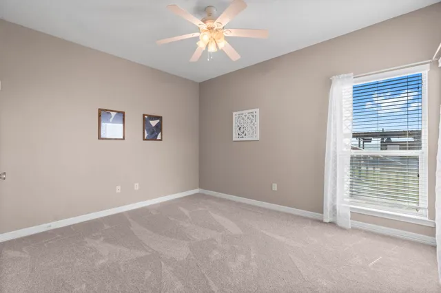 an empty room with chandelier fan