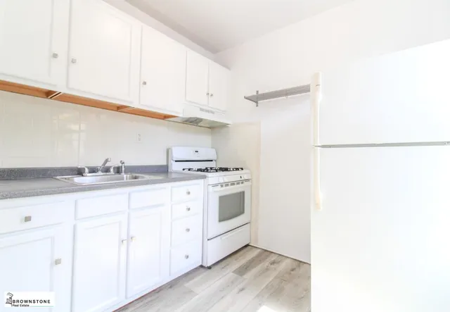 a kitchen with granite countertop white cabinets and white appliances