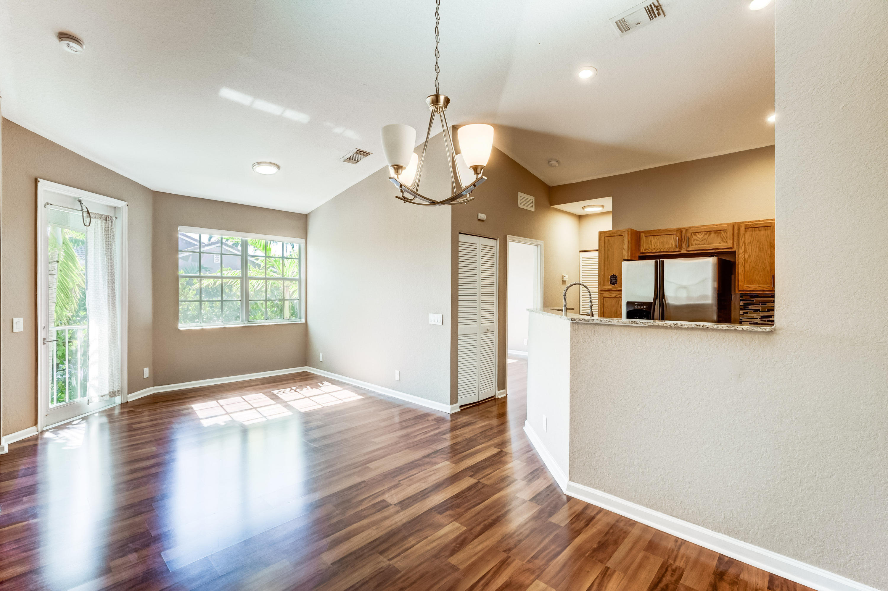 3174 Laurel Ridge Circle Riviera Beach, FL 33404 - Photo 3 of 32 a view of an empty room with wooden floor and a window