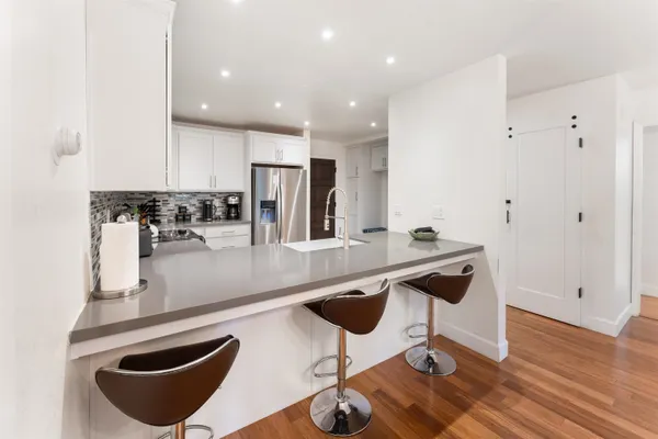 a kitchen with stainless steel appliances granite countertop a sink and a refrigerator