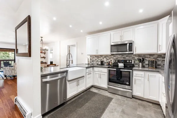 a kitchen with stainless steel appliances granite countertop a stove sink and cabinets