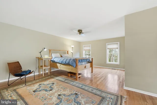 a living room with a bed furniture and next to a window
