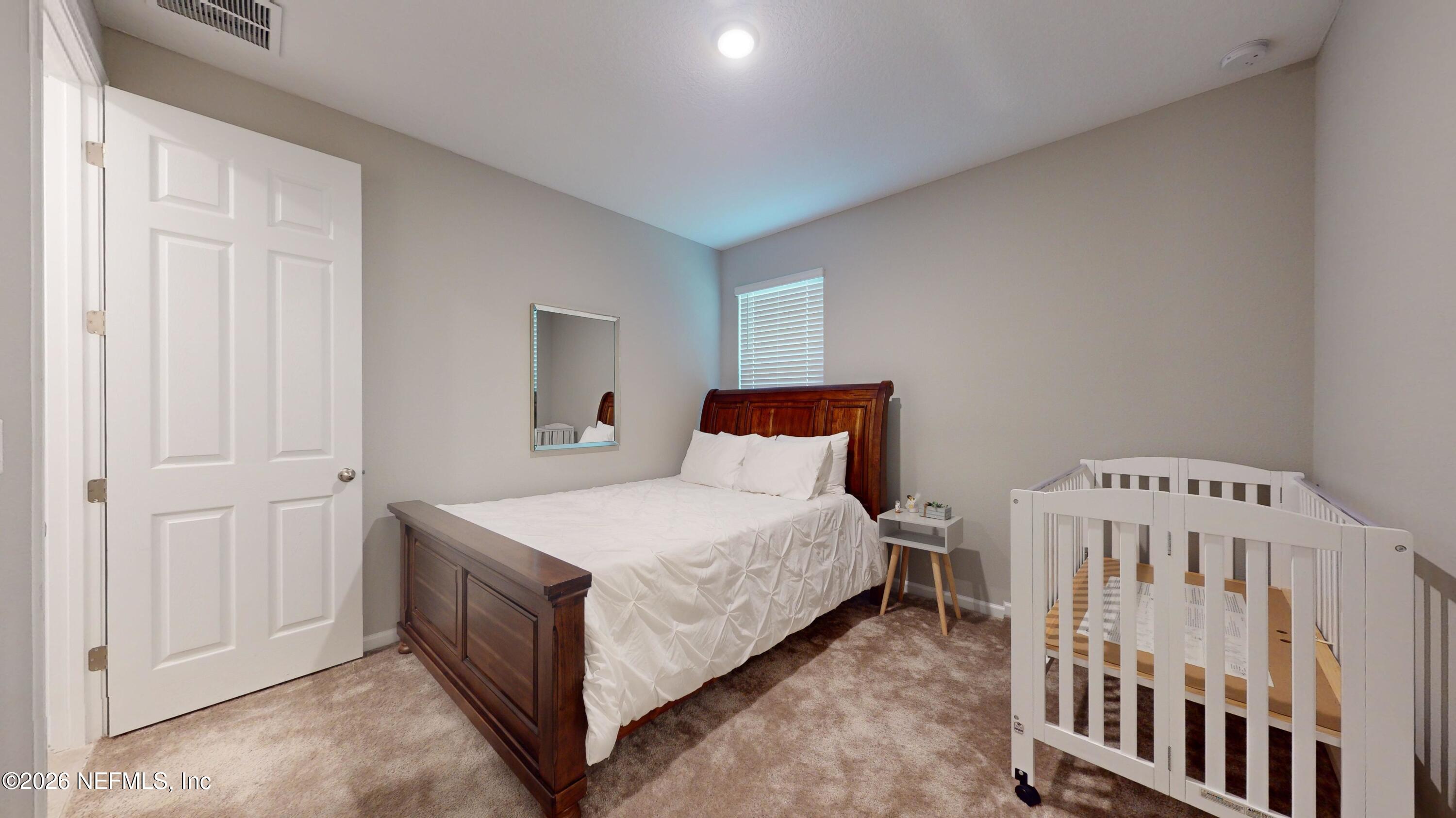 122 Field Flower Way St. Augustine, FL 32092 - Photo 12 of 55 a bedroom with a bed and a baby crib