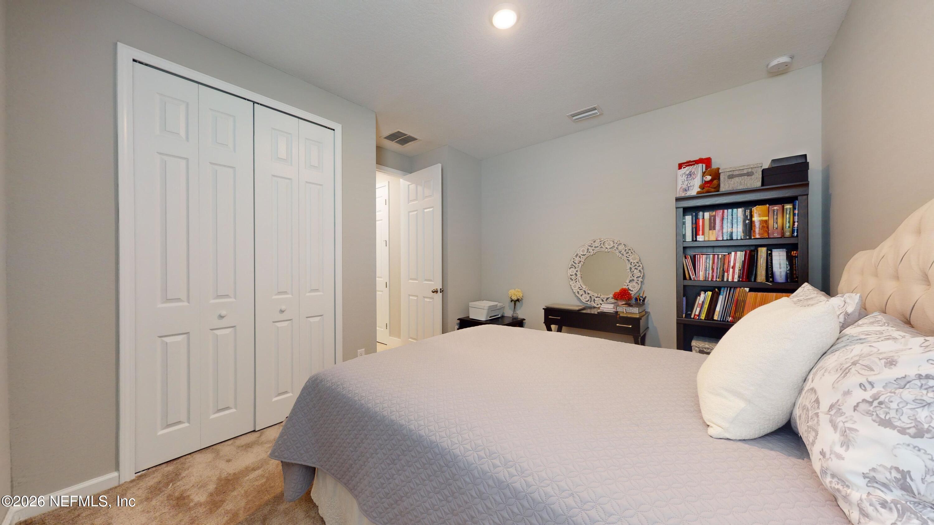 122 Field Flower Way St. Augustine, FL 32092 - Photo 16 of 55 a bedroom with a bed and a book shelf